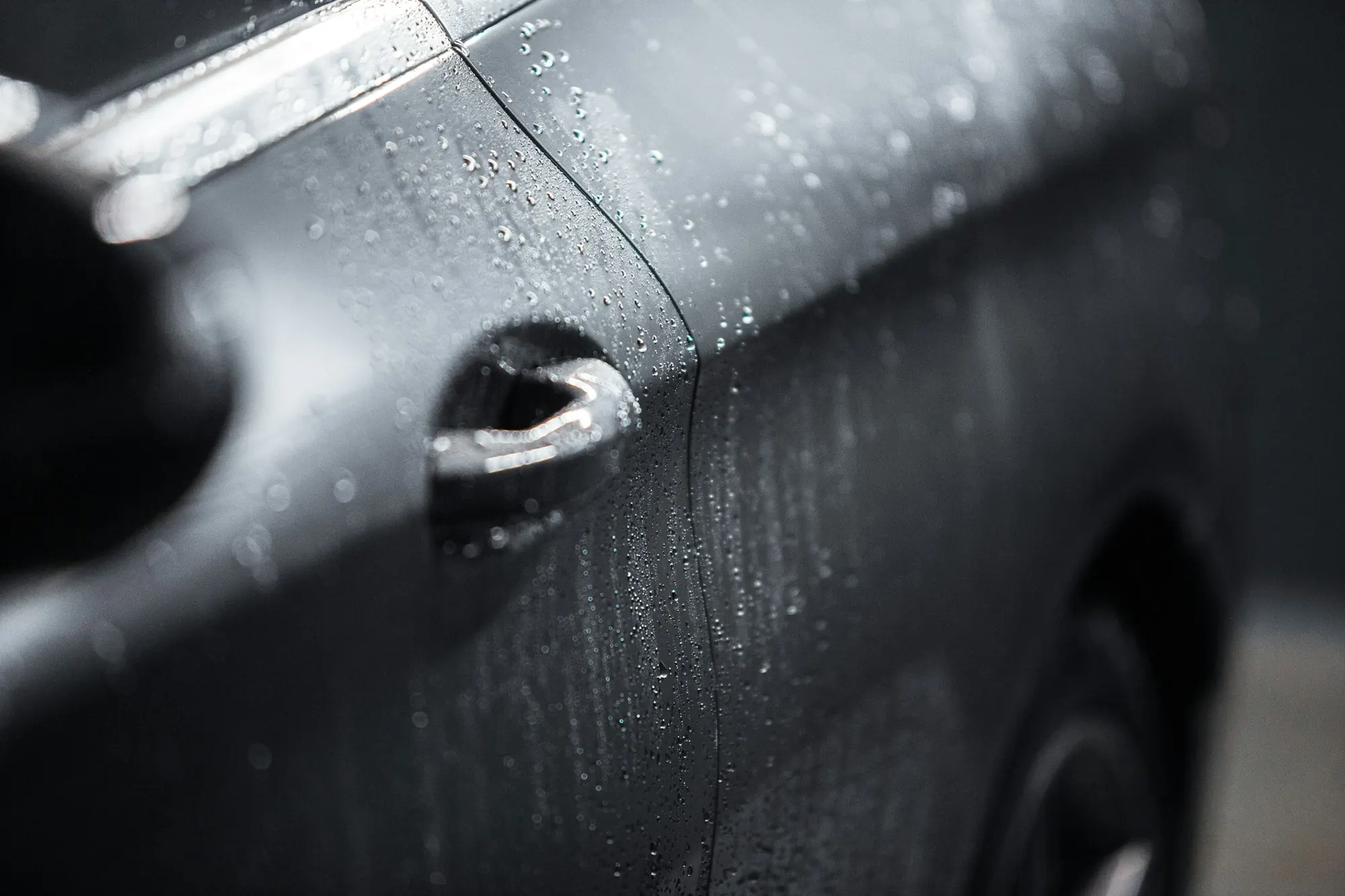Rain beading on a black car door
