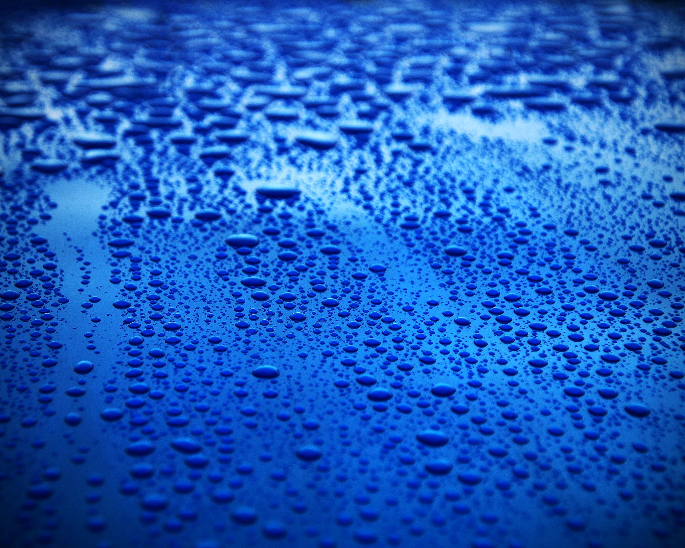 Tight water beads on glossy blue paint