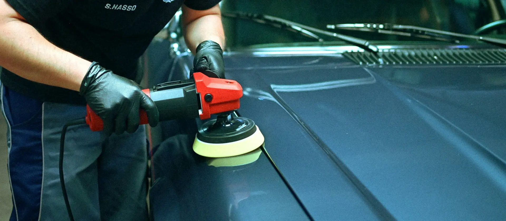 Detailer machine-polishing a panel